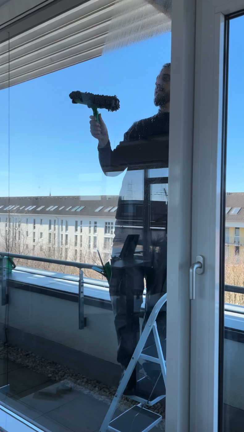 Rodi Mitarbeiter reinigt professionell ein großes Bürofenster in Köln